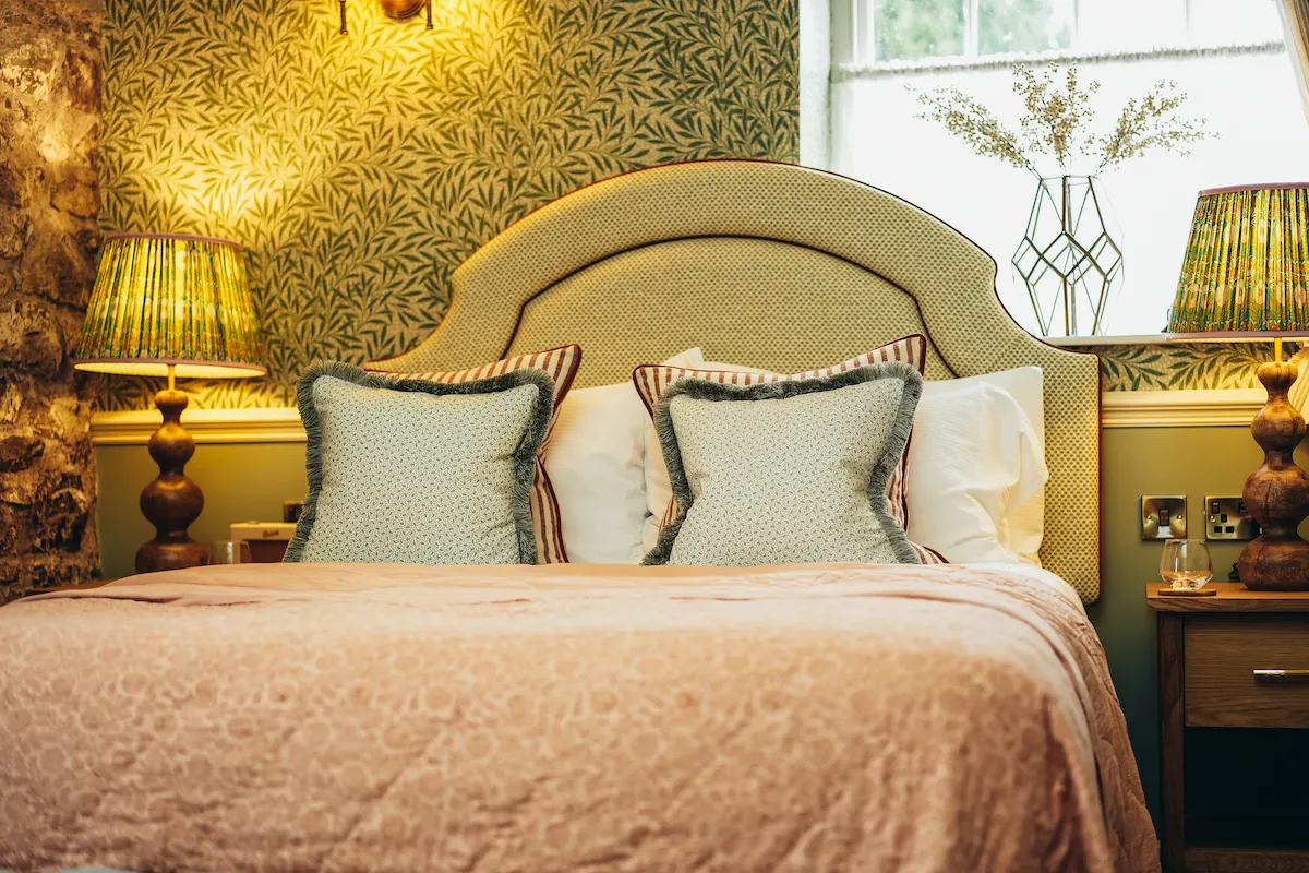 Photograph of the bed, pillows and lamp in a Deluxe Double Room